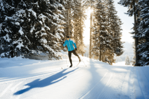 Person in teal jacket cross country skiing on a trail in Breckenridge, Co.