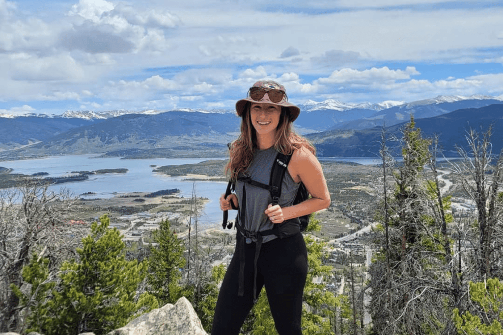 A girl standing on the top of a hike in Frisco, Colorado during a day trip from Breckenridge.